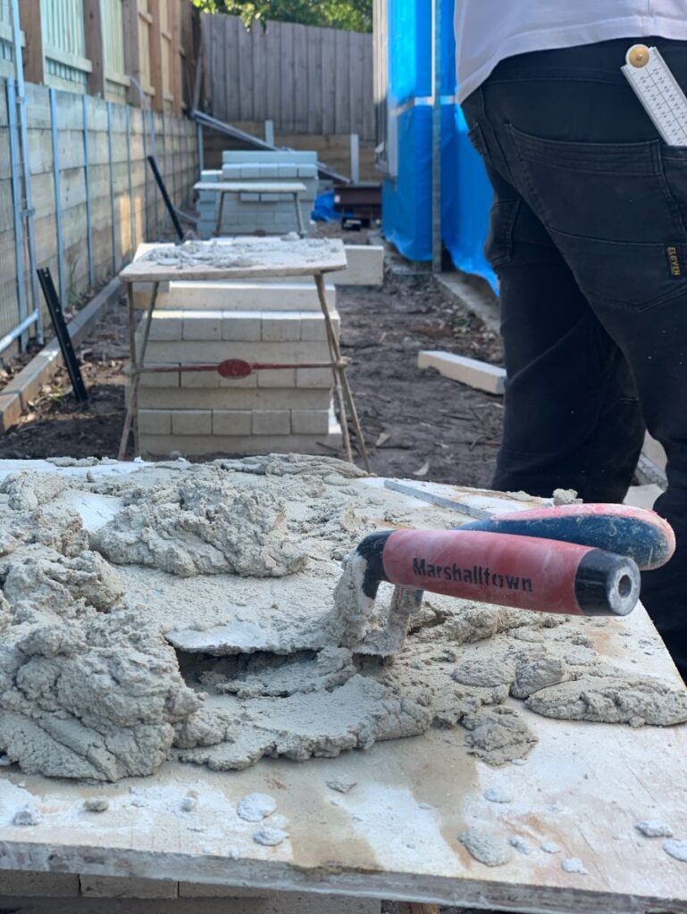 Photo of a board of mud being used by bricklayers Hobart for building a new brick fence